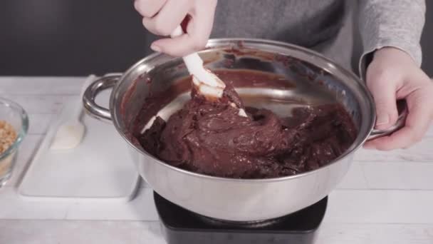 一歩ずつ マカダミアナッツファッジを作るために調理鍋にチョコレートチップを溶かす — ストック動画