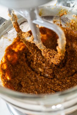 Karıştırıcı pekmez, yumurta, tereyağı ve şekeri karıştırarak çikolatalı zencefilli kurabiye için yumuşak ve zengin bir taban oluşturuyor. Bu karışım hamura derin bir tat ve nem katıyor..