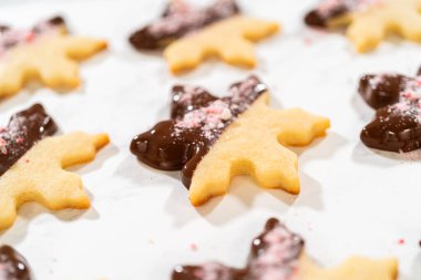 Parşömen kağıdında ezilmiş nane şekeriyle kaplı çikolata soslu kar tanesi şekerli kurabiyenin yakın çekimi..