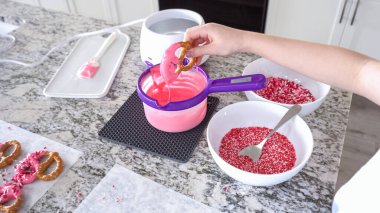 Odaklanmış bir dikkatle, bu filizlenen aşçılık sanatçısı krakerleri erimiş çikolataya batırarak iyi aydınlatılmış bir ev mutfağının sıcaklığında tatlı tatlar yaratıyor..