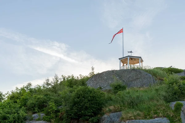 Mandal, Noruega - junio 2018: Uranienborg, el hermoso mirador en Mandal, una pequeña ciudad en el sur de Noruega. Chica de pie dentro del pabellón, desde donde se puede ver la ciudad desde arriba . — Foto de Stock