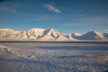 Kar, Svalbard 'daki Longyearbyen' den görülen dağları kapladı.