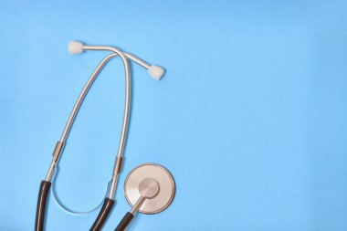 İzole mavi arka plan üzerinde siyah stetoskop