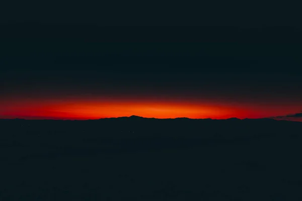 Bergtoppen en wolken bij zonsopgang — Stockfoto