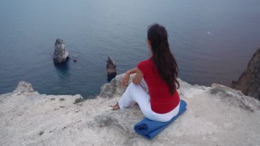 deniz, kayaya oturan kız Lotus yoga poz, konsantre, rahatlatıcı zihin, ruh ve beden içinde meditasyon.