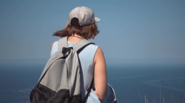 Bir güzel genç turist kız portresi bir deniz feneri, hasır şapkalı bir sırt çantası ile bakıyor,