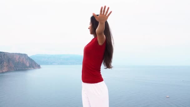 Ung smal kvinna gör yogaställning nära havet — Stockvideo