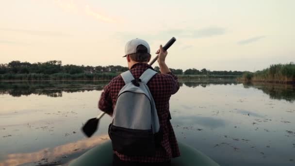 El hombre nada en un kayak en un río tranquilo. Ella remo hábilmente . — Vídeos de Stock