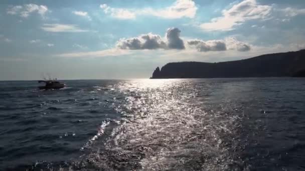 Vista de um barco no mar que vem em torno de uma costa rochosa — Vídeo de Stock