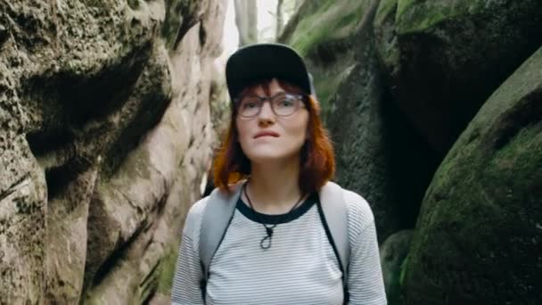 Portrait fille en verre avec un sac à dos marchant à travers les montagnes vertes . — Video