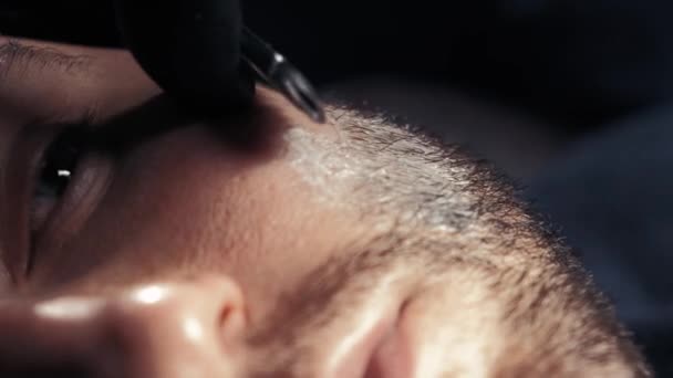 Close up van een knappe man krijgt van zijn baard geschoren in een kapsalon professionele kapper met behulp van een scheermes scheren zijn klant beroep. — Stockvideo