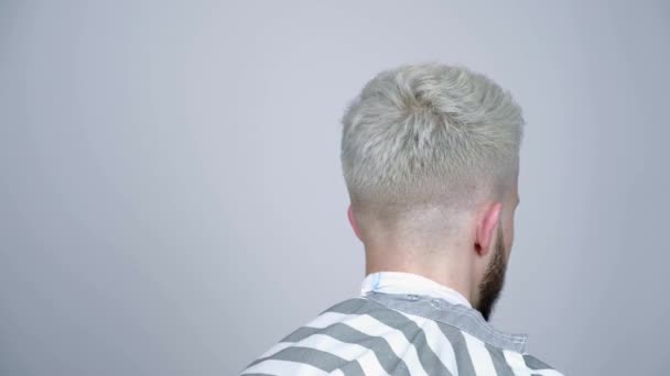 Blond young man looking to the side stroking his beard. — Stock Video