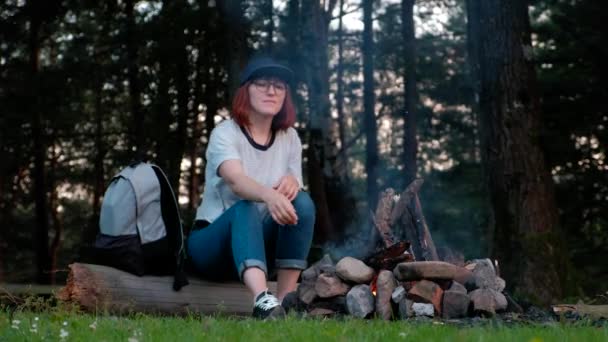 Das Mädchen im Wald in der Nähe des Feuers. — Stockvideo