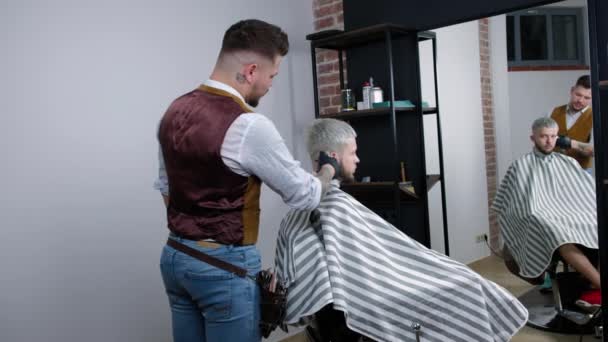 Barbeiro Tatuado Faz Corte Cabelo Para Cliente Barbearia Usando Hairclipper — Vídeo de Stock