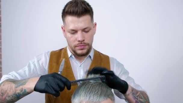 Man krijgt een kapsel door een kapper. kapsel close-up schaar — Stockvideo