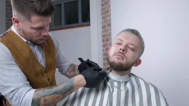 Afeitarse la barba. Peluquero corte mens cara pelo con recortadora de barba en la barbería . — Vídeos de Stock