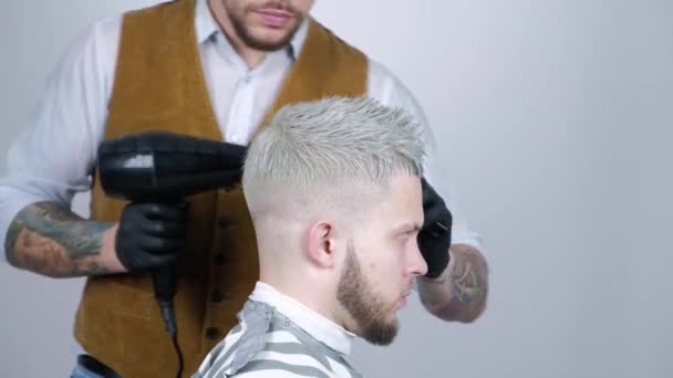 Penteado masculino no salão. Homem secagem de cabelo na barbearia. Cabelo estilo barbeiro com secador. Termine o cabeleireiro. Secador de cabelo homem na barbearia — Vídeo de Stock
