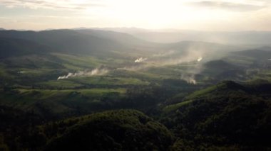 Hava dron görüntüleri İzlenme: Ormanlar, alanları ve nehir gündoğumu yumuşak ışık sonbahar dağ köyü üzerinden uçuş.