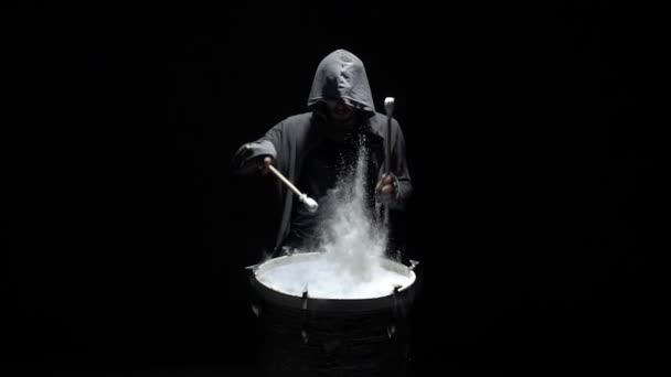 Hooded man beats drum with flour — Stock Video