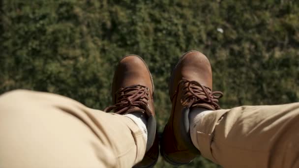 Летают над красивыми лесами. Снимок с камеры и человеческие ноги в синих кроссовках в рамке. Пейзажная панорама . — стоковое видео