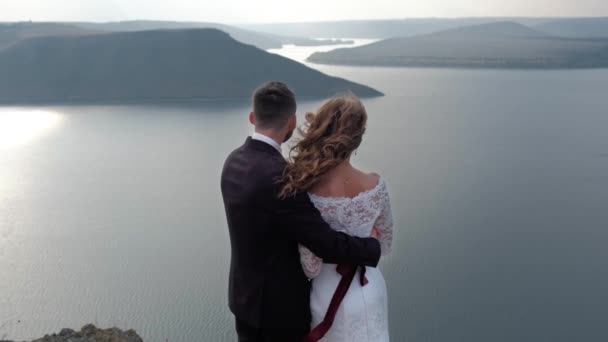 Magical and mystical couple looks at the coast from a cliff. — Stock Video