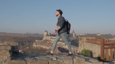 Adam seyahat etmek sırt çantası ile şehir ve sahil panoramik manzaraya bakarak şehir araştırıyor. Seyahat kavramını yeni yerler keşfetmek.