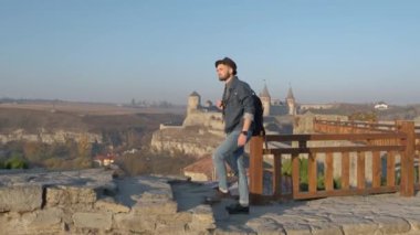 Adam seyahat etmek sırt çantası ile şehir ve sahil panoramik manzaraya bakarak şehir araştırıyor. Seyahat kavramını yeni yerler keşfetmek.