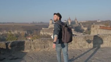 Adam seyahat etmek sırt çantası ile şehir ve sahil panoramik manzaraya bakarak şehir araştırıyor. Seyahat kavramını yeni yerler keşfetmek.