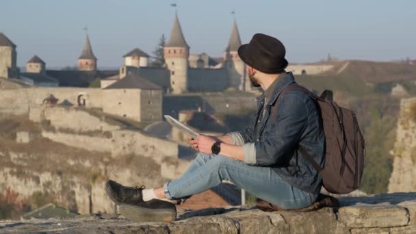 Joven viajero hombre con mapa al aire libre, antiguo fondo del castillo — Vídeo de stock