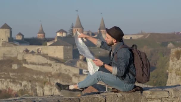 Młody podróżnik człowiek z mapy na zewnątrz, tle zamczysko — Wideo stockowe