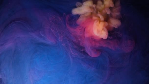 Abstracte psychedelische achtergrond. Gele en rode inkt wordt gegoten in blauwe vloeistof in slow motion — Stockvideo