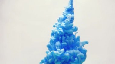 Su mavi mürekkeple. Yaratıcı ağır çekim. Beyaz bir arka plan üzerinde.