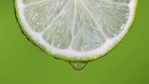 Cal fresca, una gota de agua cae. La fruta emite frescura y relleno de jugo. Fondo verde — Vídeos de Stock