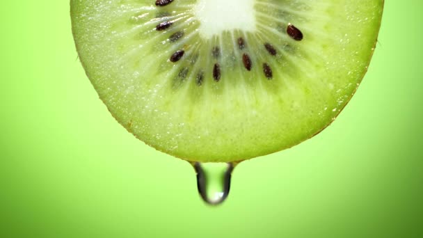 Close up or macro of a slice of kiwi, a drop of water falls in slow motion.