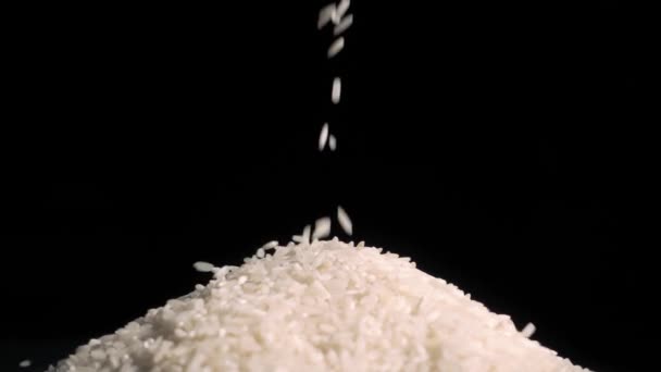 El pirinç taneleri tutar. siyah arka plan — Stok video