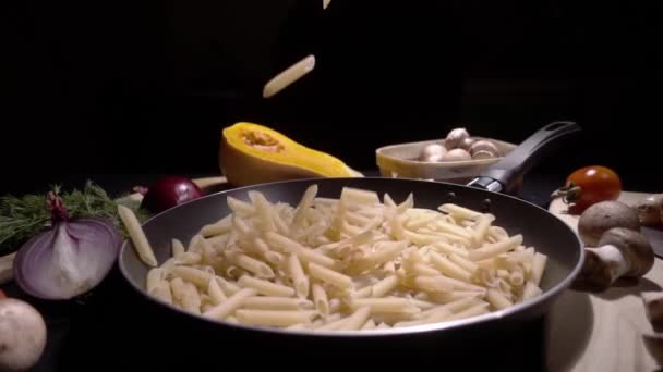 Τηγάνι με ακατέργαστο ζυμαρικά μακαρόνια. Πέφτουν σε αργή κίνηση — Αρχείο Βίντεο