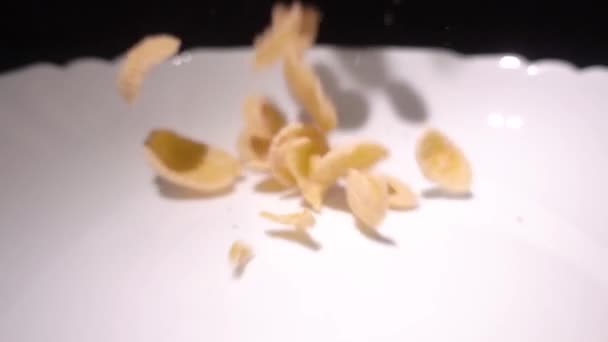Super cámara lenta copos de maíz cayendo en un tazón de leche vista superior — Vídeo de stock