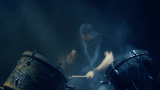 Мужчина играет на барабане в синем свете . — стоковое видео