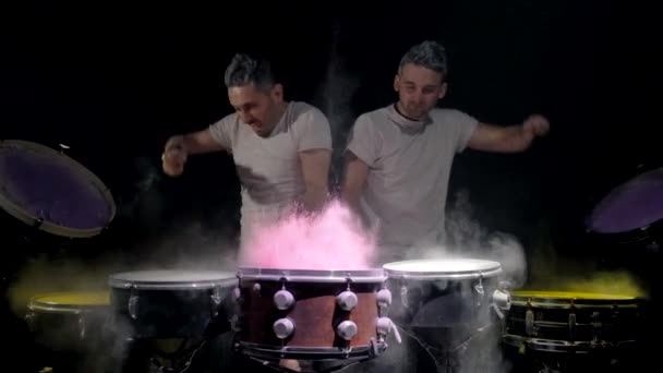 Två unga män som spelar trumman. Färgade holi pulver — Stockvideo