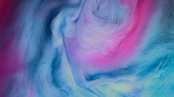 Blue pink clouds of ink in liquid. black background