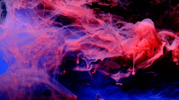 Blue and Red Ink mixing together over a pure black background. — Stock Photo, Image