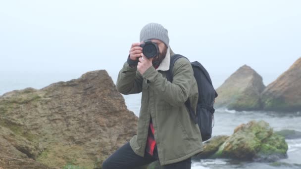 Photographe de plein air avec une barbe capturant une mer orageuse — Video