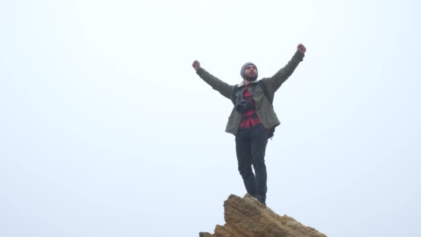 Hiker on top of a mountain arms raised to the sky — Stock Video