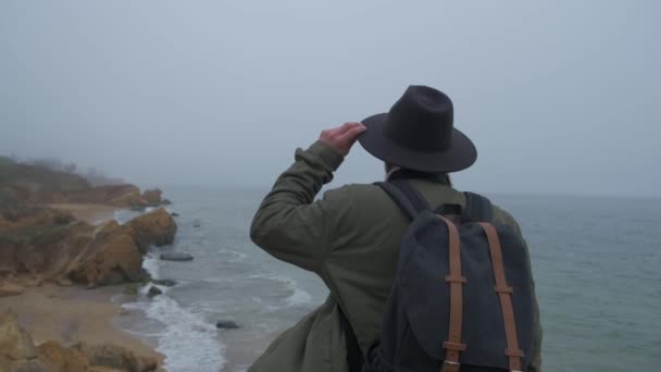 Τουρίστρια με σακίδιο σε μια βόλτα στην άκρη ενός βράχου — Αρχείο Βίντεο