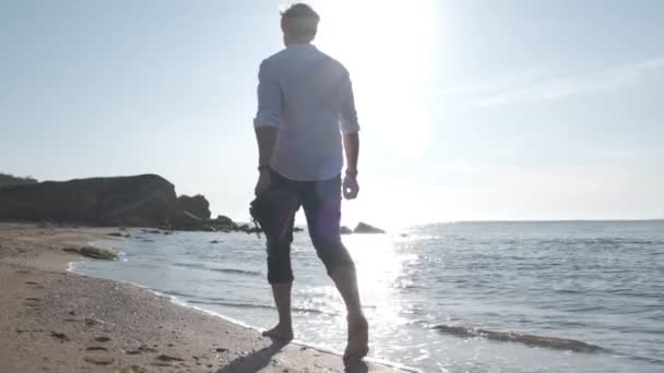 Ragazzo che cammina sulla spiaggia del mare all'alba — Video Stock