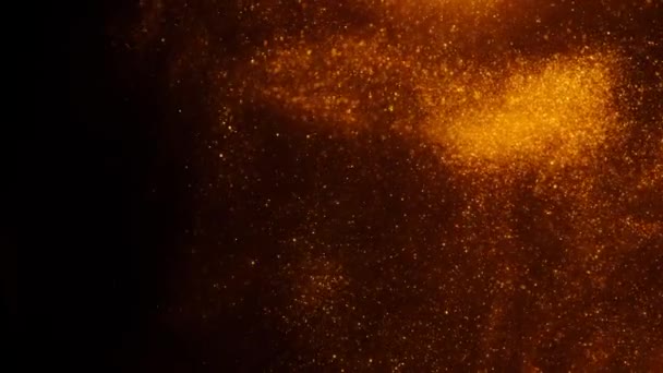 Goudkleurig zand of stof creëert abstracte formaties in de vorm van de zon op een zwarte achtergrond. Kunstachtergronden. — Stockvideo