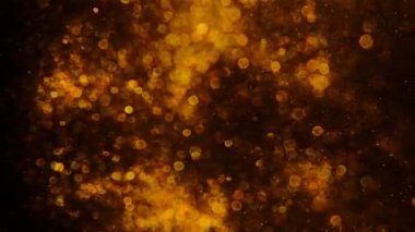 Siyah arka plan bulanıklığı üzerinde altın tozu