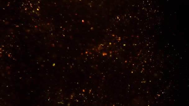 Siyah arka plan bulanıklığı üzerinde altın tozu — Stok video