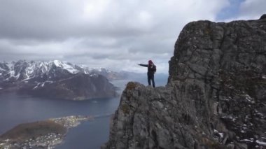 Manzaralı güzel Lofoten Adaları sahne bakan dağ tepesinde erkek otostopçu hava görüntüleri, takımadalar Norveç,