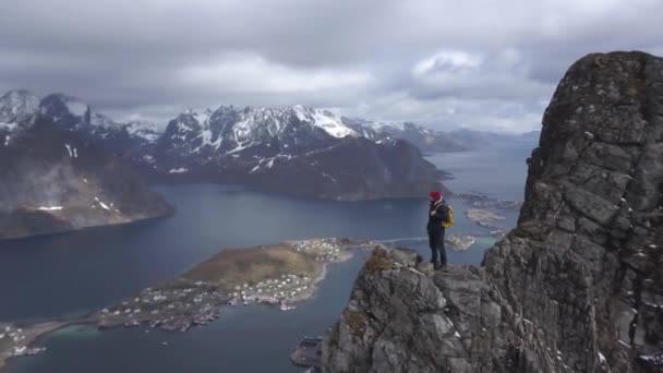 Luchtfoto beelden van mannelijke wandelaar op bergtop met uitzicht op de prachtige Lofoten eilanden landschap in Scenic, archipel Noorwegen, — Stockvideo